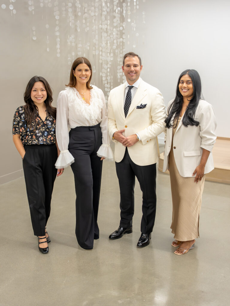 Four nicely dressed people pose