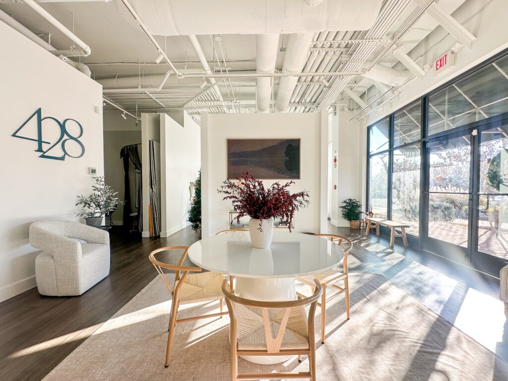 An entry of a business with a table, sitting chair, and a screen on the wall