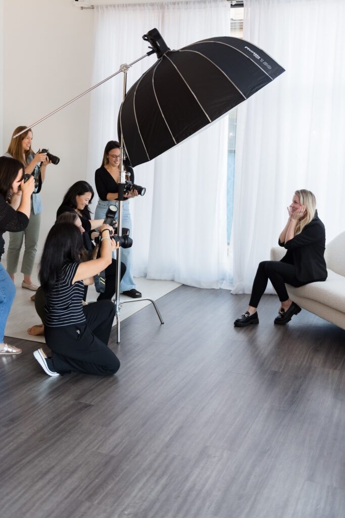 Photographers take pictures of a woman sitting down